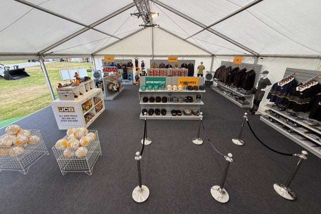 A marquee containing shop shelves display workwear for JCB